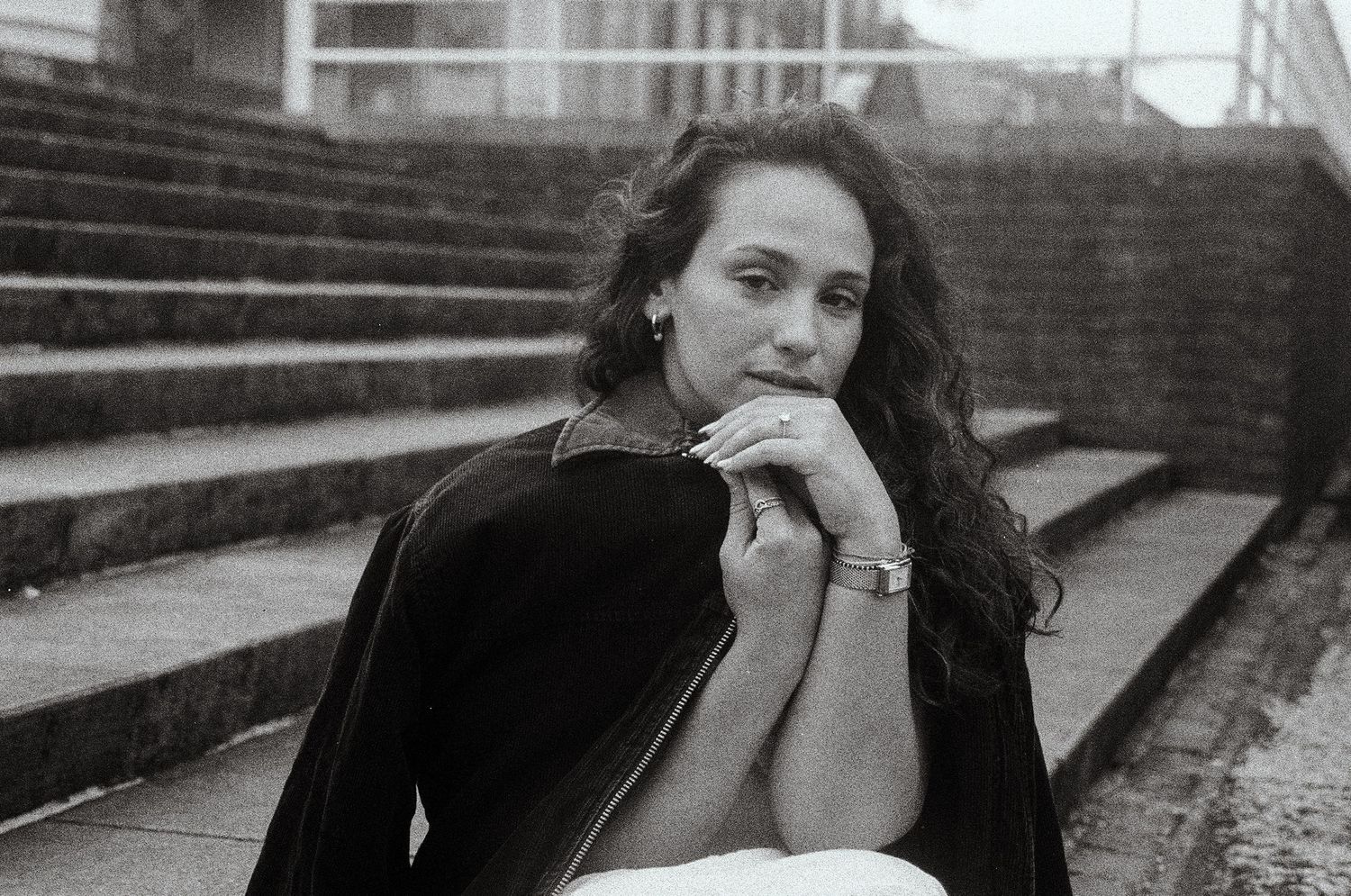 Black and white 35mm film portrait of a woman sitting on stairs