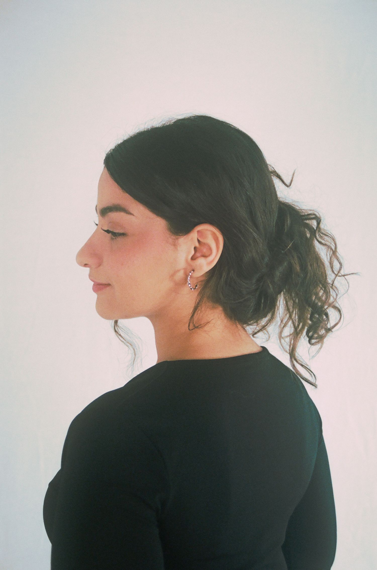 A colored portrait 35mm film of a side profile of a woman