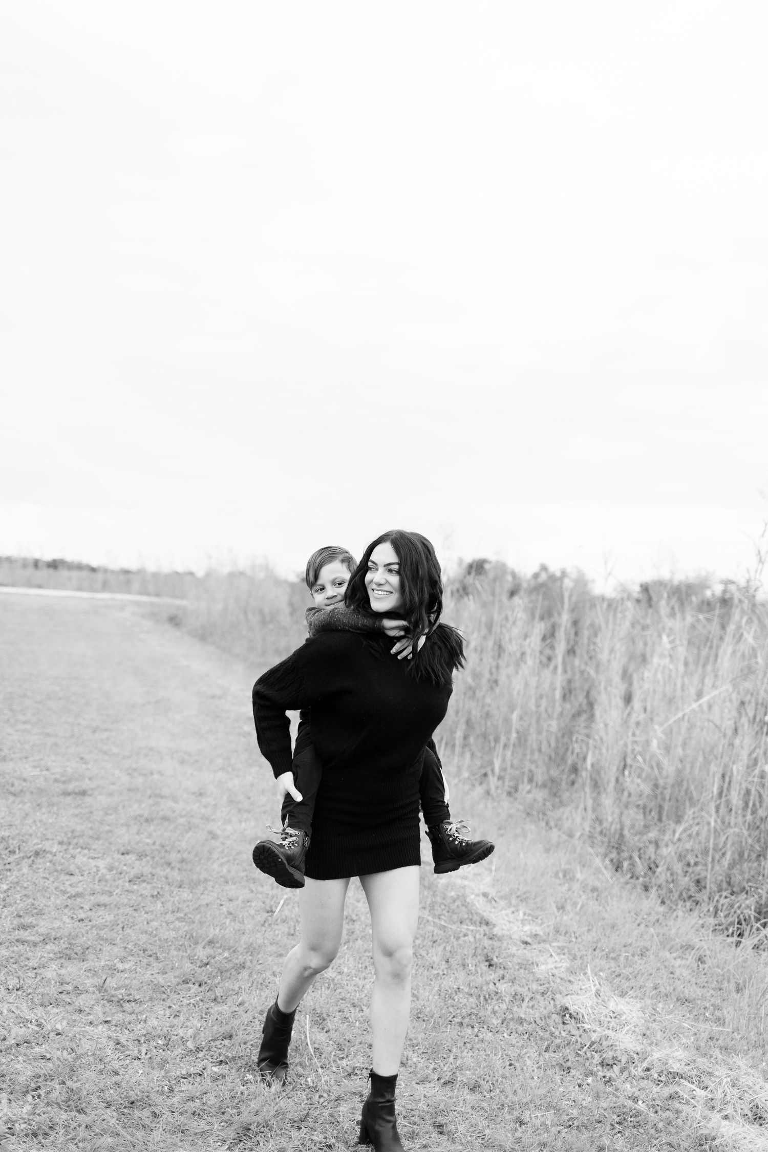 mom holding son laughing and running during mommy and me photoshoot in Boynton beach