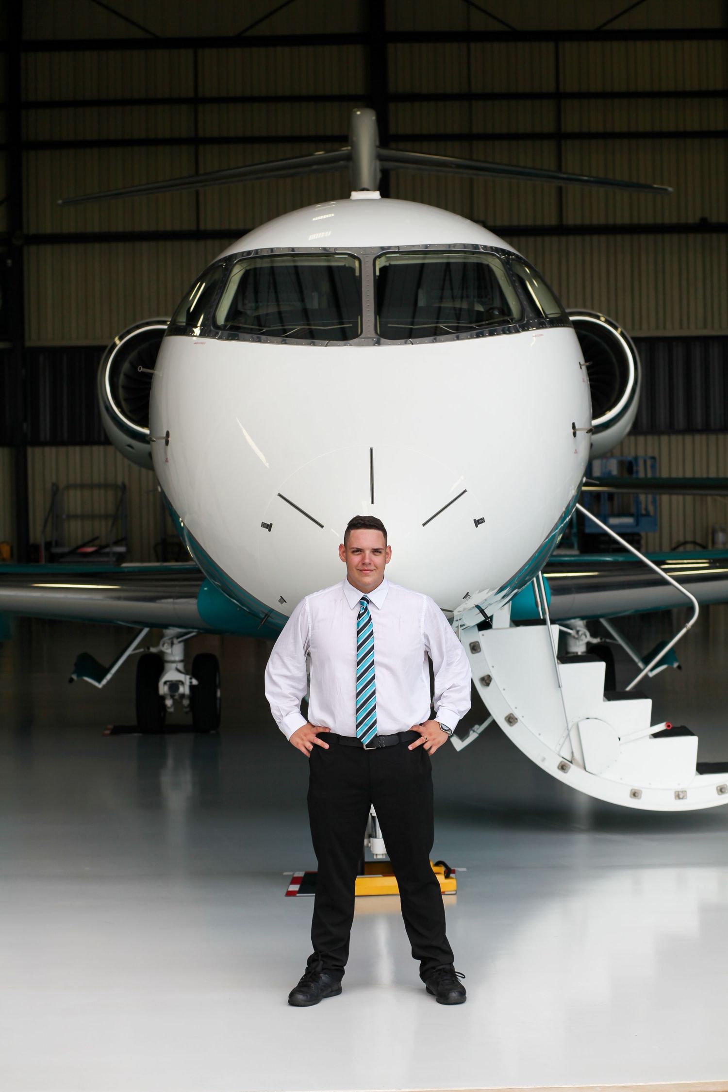 high school graduation photos. high school graduate posing with plane.