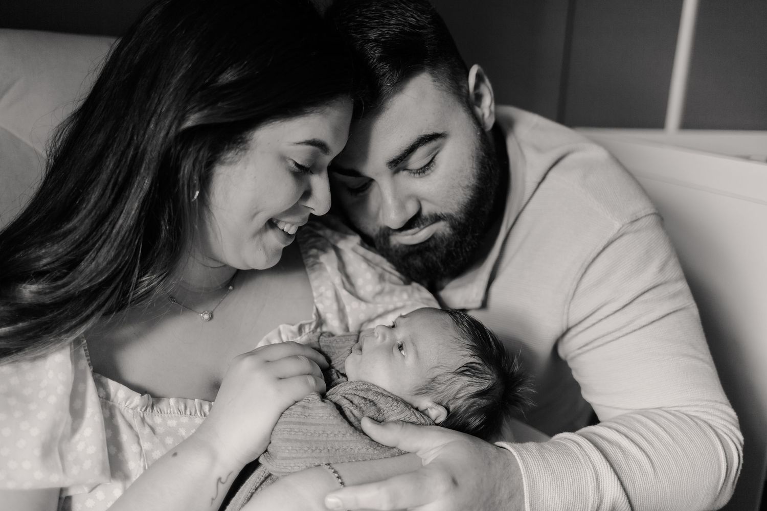 In home newborn photoshoot. parents holding newborn baby smiling