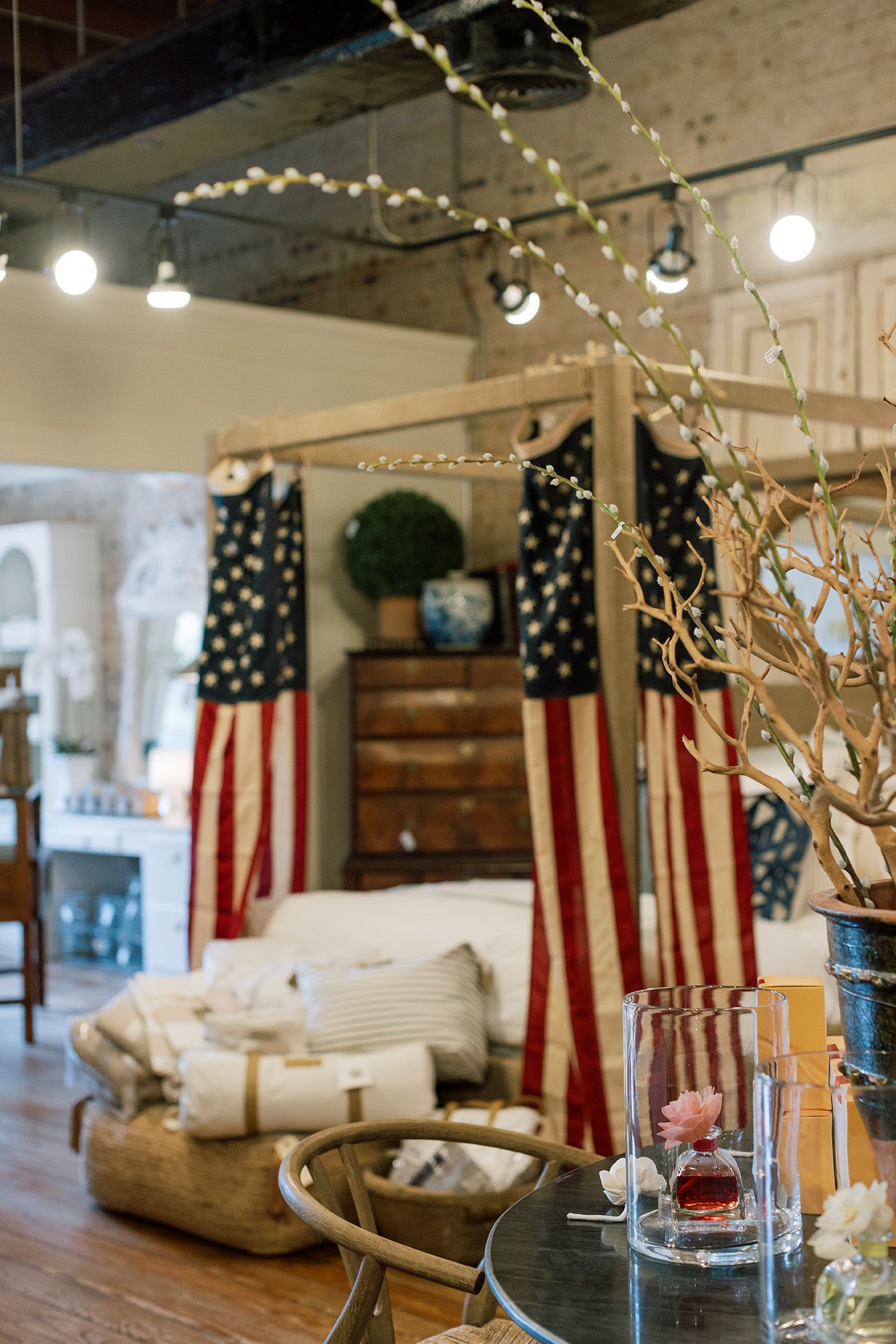 Rustic interior decor display featuring American flag canopy bed and string lights.
