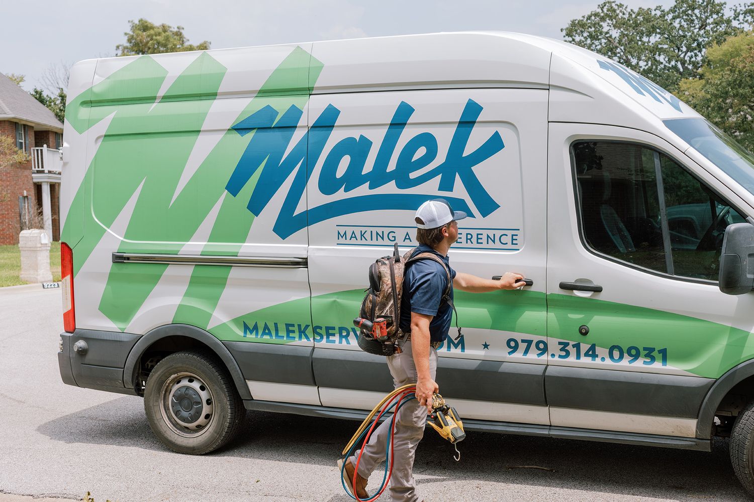 Malek Making A Difference branded service van parked outside a residential home.
