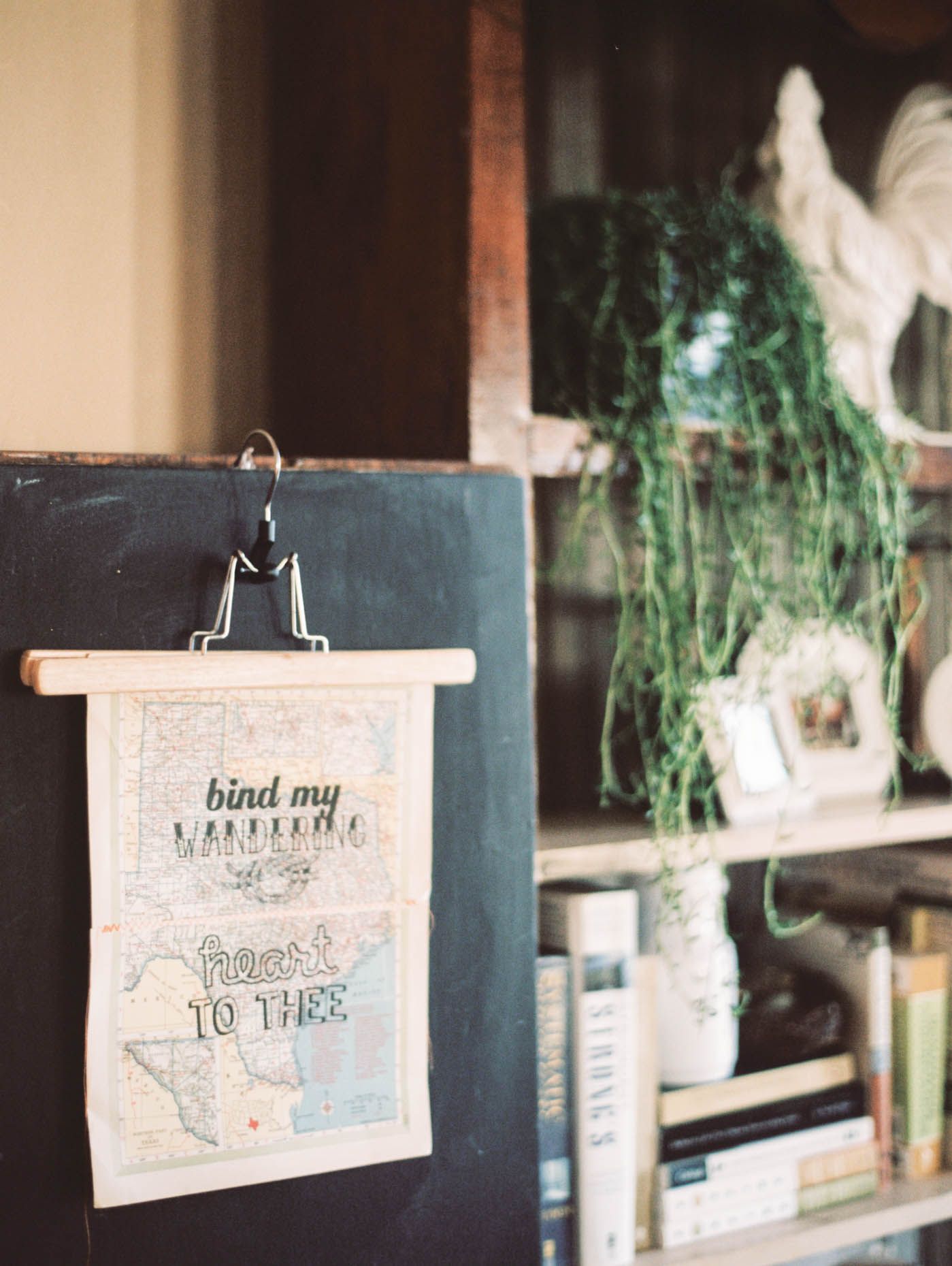 Decorative map art hanging on chalkboard reading bind my wandering heart to thee.