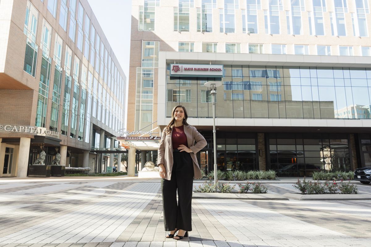 Confident businesswoman poses outdoors in urban setting near Bush George W. Bush Institute.