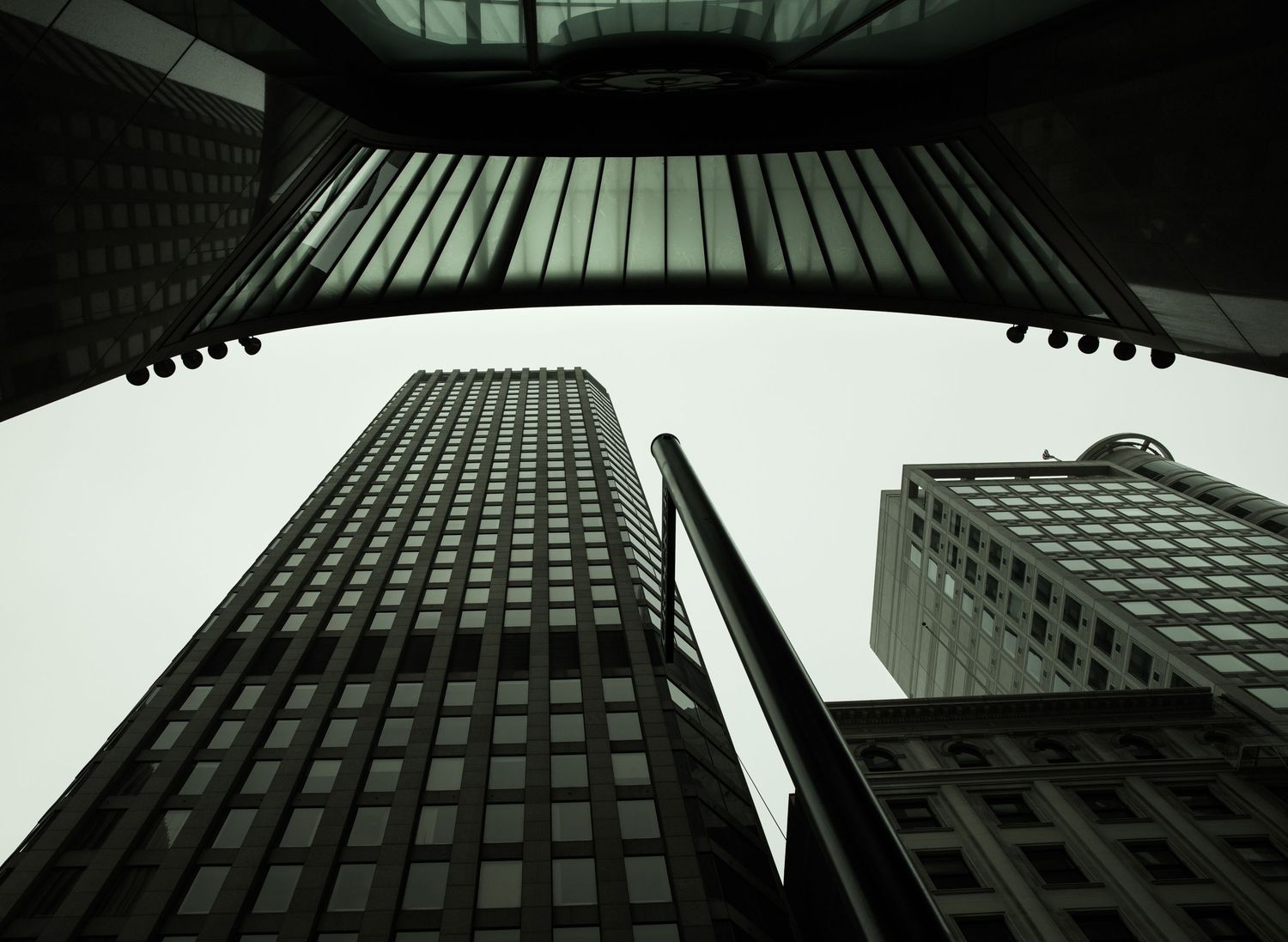 Upward view of San Francisco skyscrapers framed by modern architecture, capturing dramatic lines and urban geometry downtown.