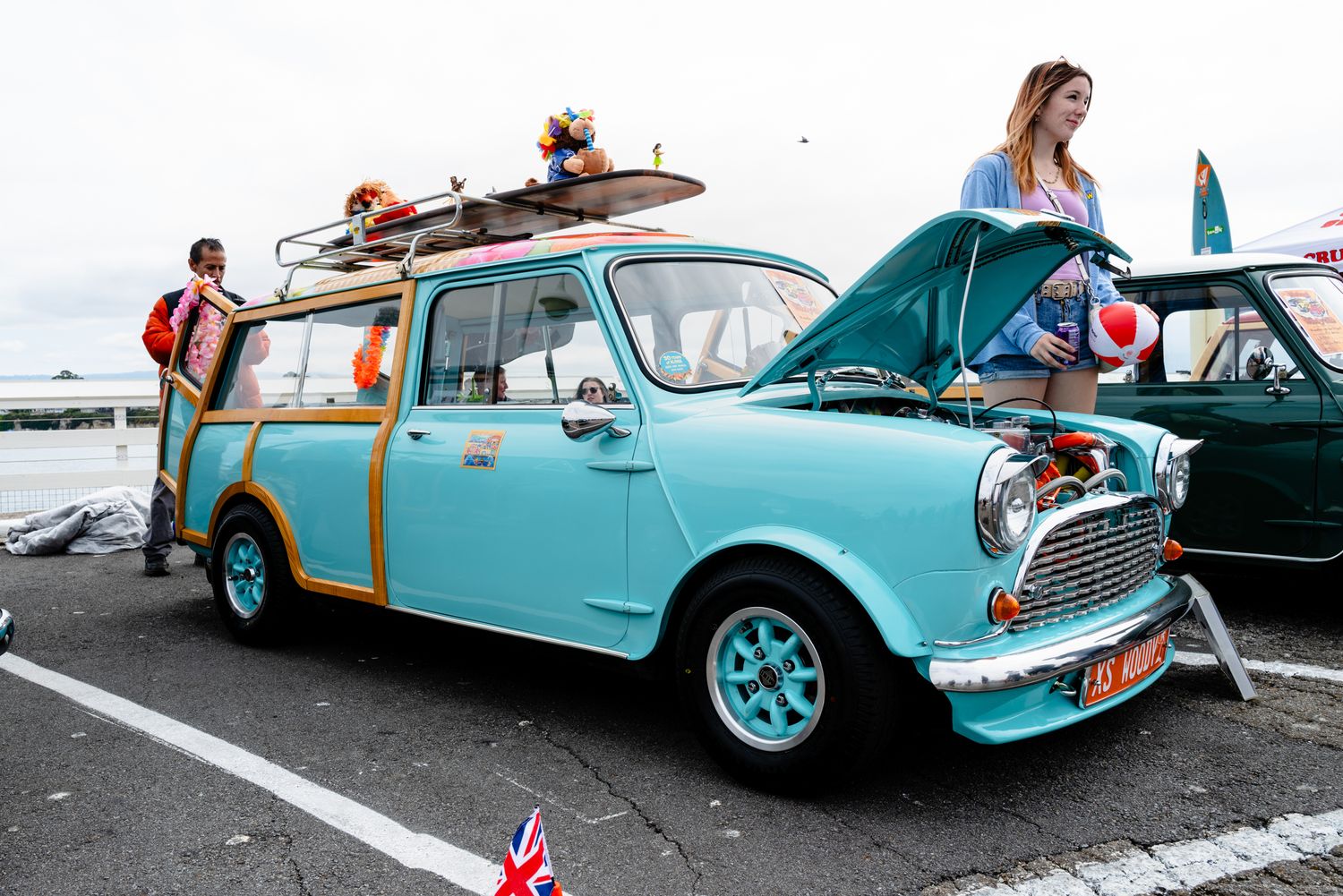 Turquoise Mini Woodie wagon displayed at Santa Cruz Wharf, California, celebrating classic surf and vintage car culture.