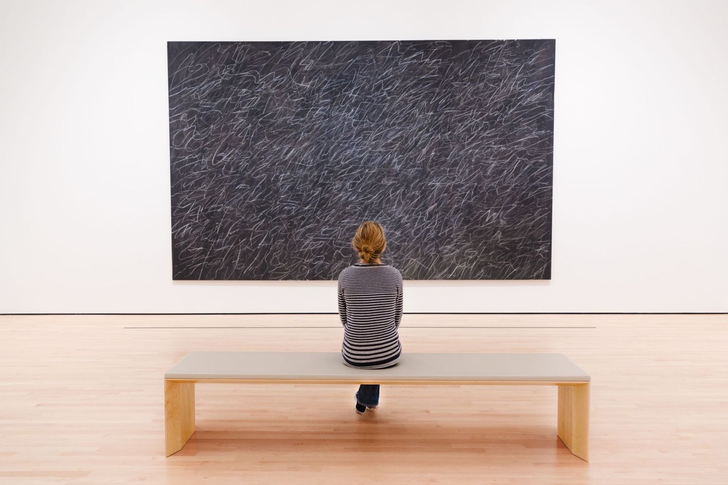 Visitor contemplates a large abstract painting at SFMOMA, capturing quiet reflection and minimalist contemporary art.