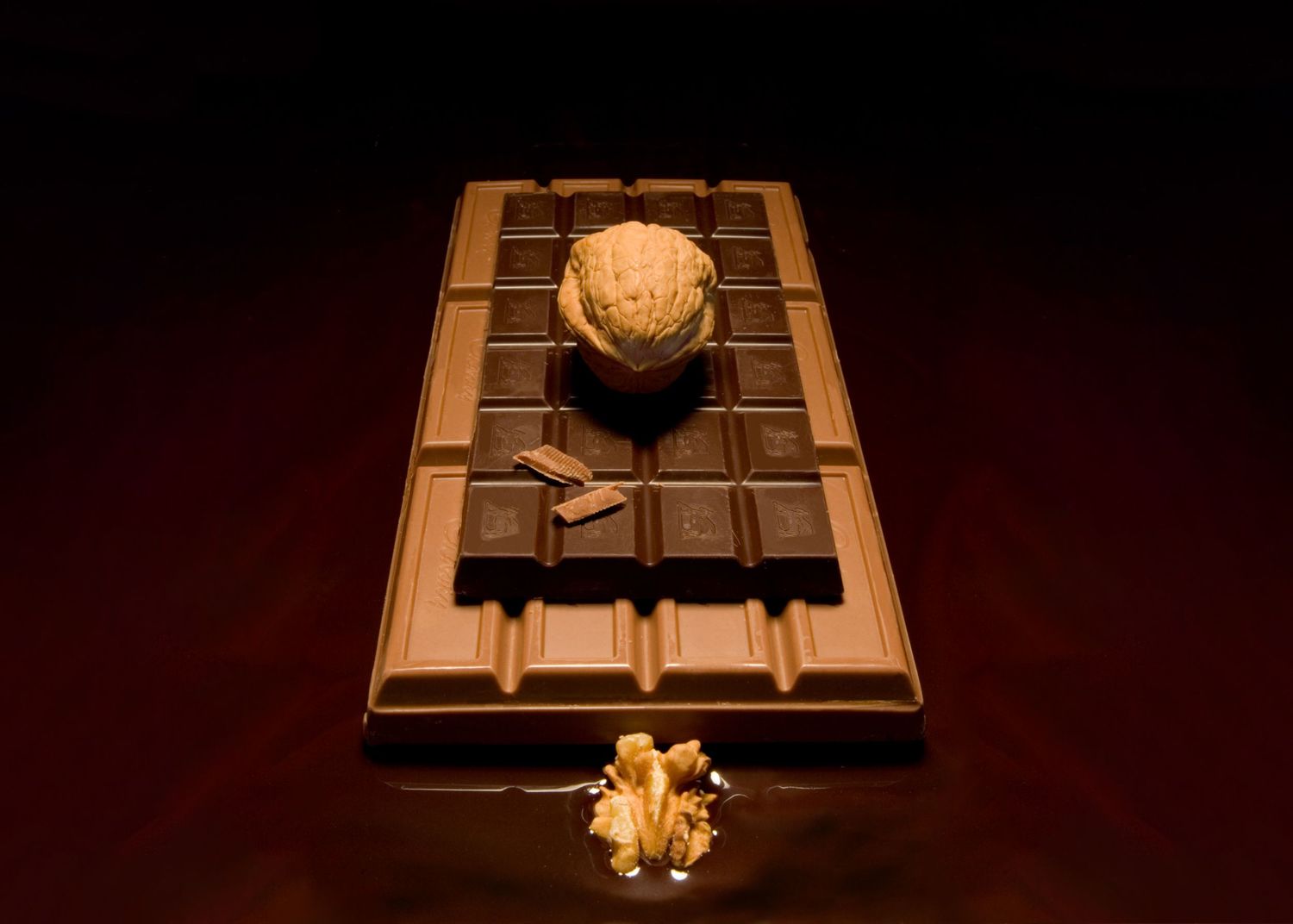 Surreal fine art still life of a walnut on layered chocolate bars with melted chocolate, exploring texture, contrast, and temptation.