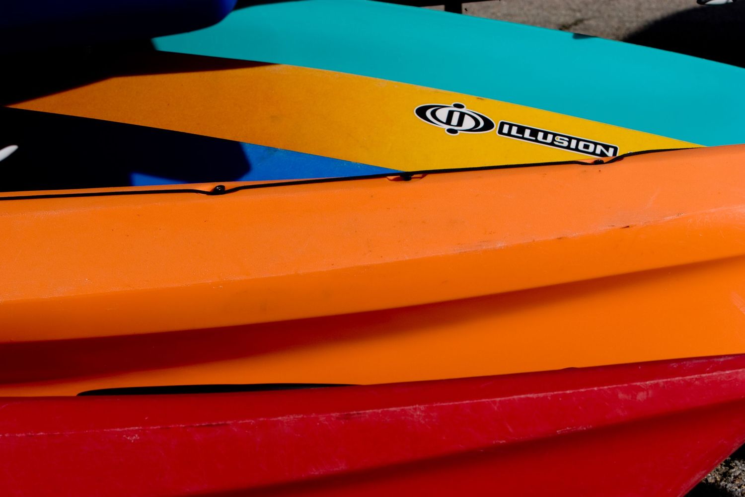 Colorful stacked kayaks at Santa Cruz, California, creating a bold abstract pattern along the vibrant Central Coast waterfront.