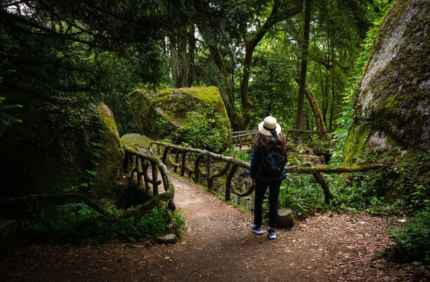 Woman in a white hat on a mossy forest path in Bom Jesus do Monte Gardens, Braga, Portugal, from the FotoMunki Hat Series.