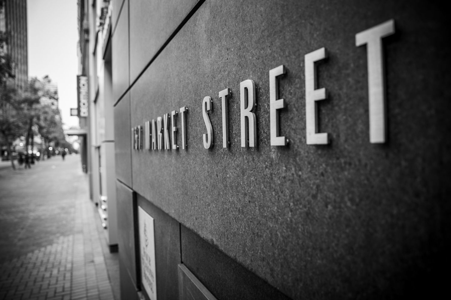 Black and white photo of the Market Street sign in downtown San Francisco with shallow focus and minimalist urban perspective.