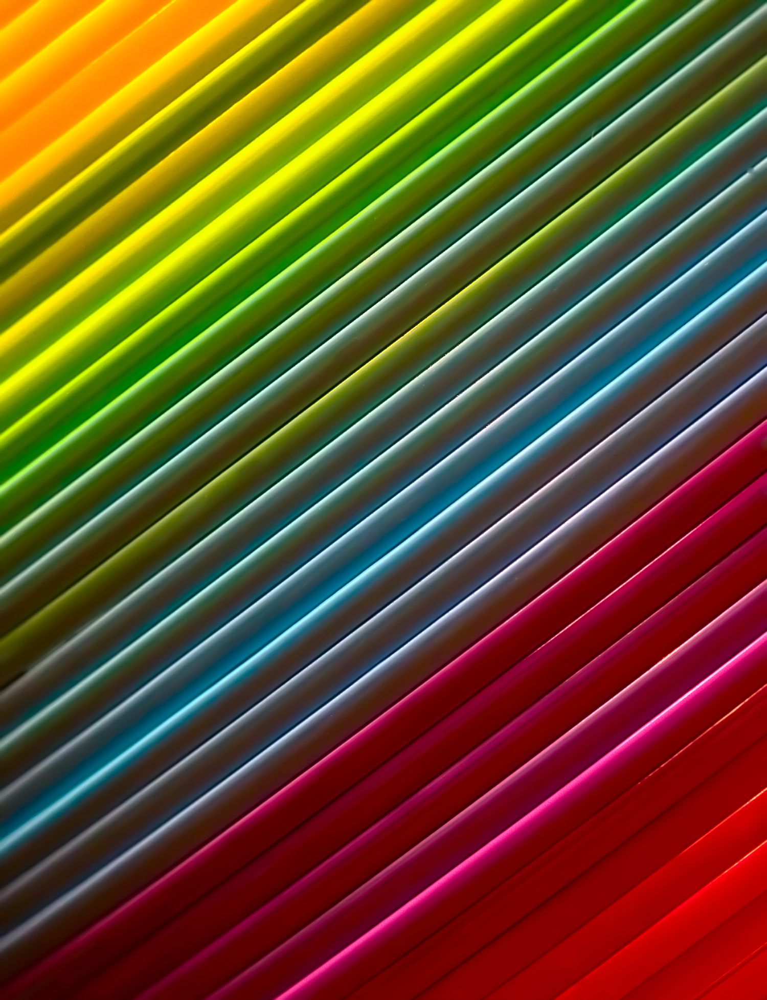 Macro abstract of a rainbow-colored Slinky toy with vibrant diagonal coils creating a colorful geometric fine art composition.