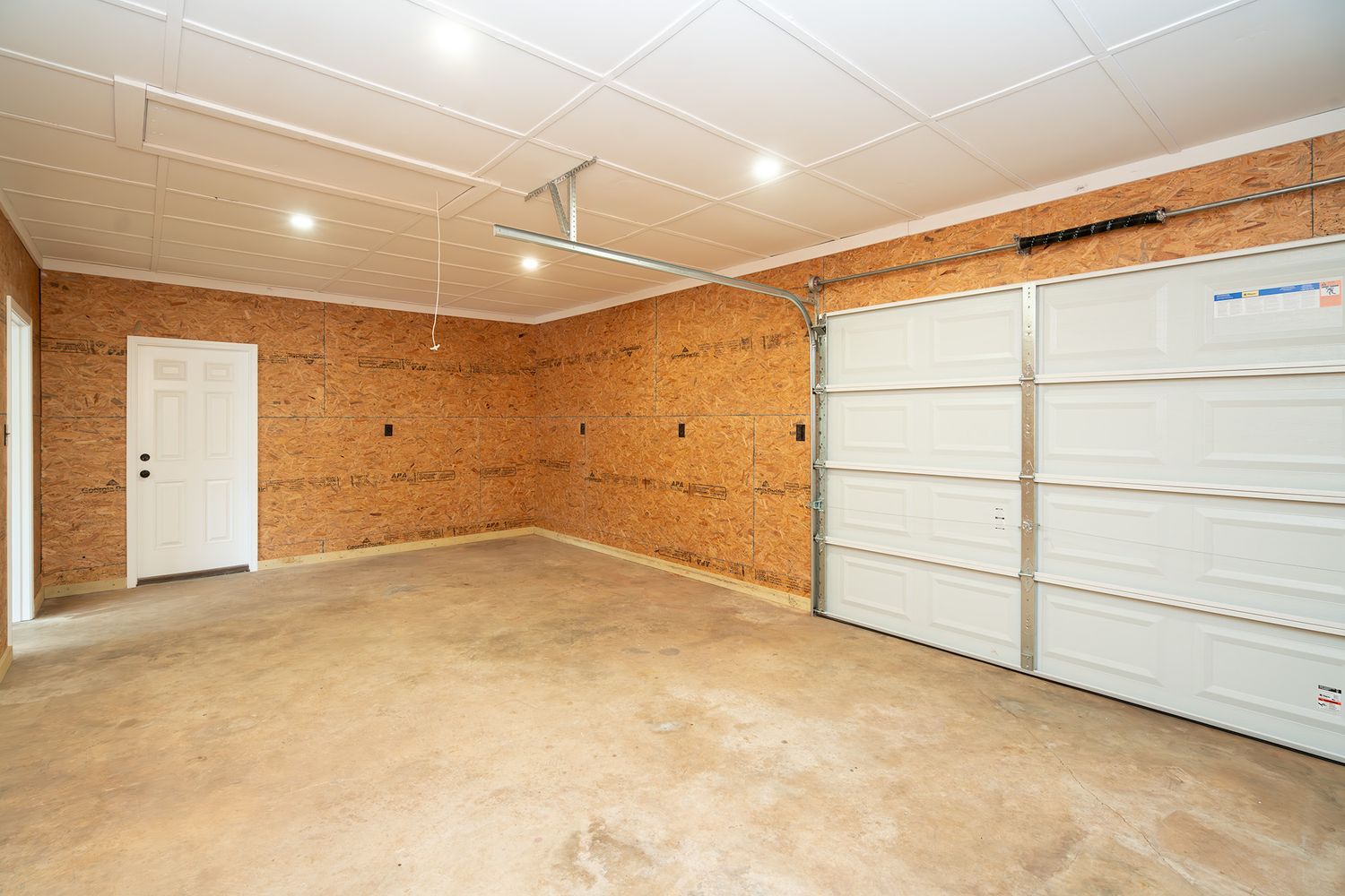Second garage with exterior door and single car garage door at rear of house that is connected to main garage.