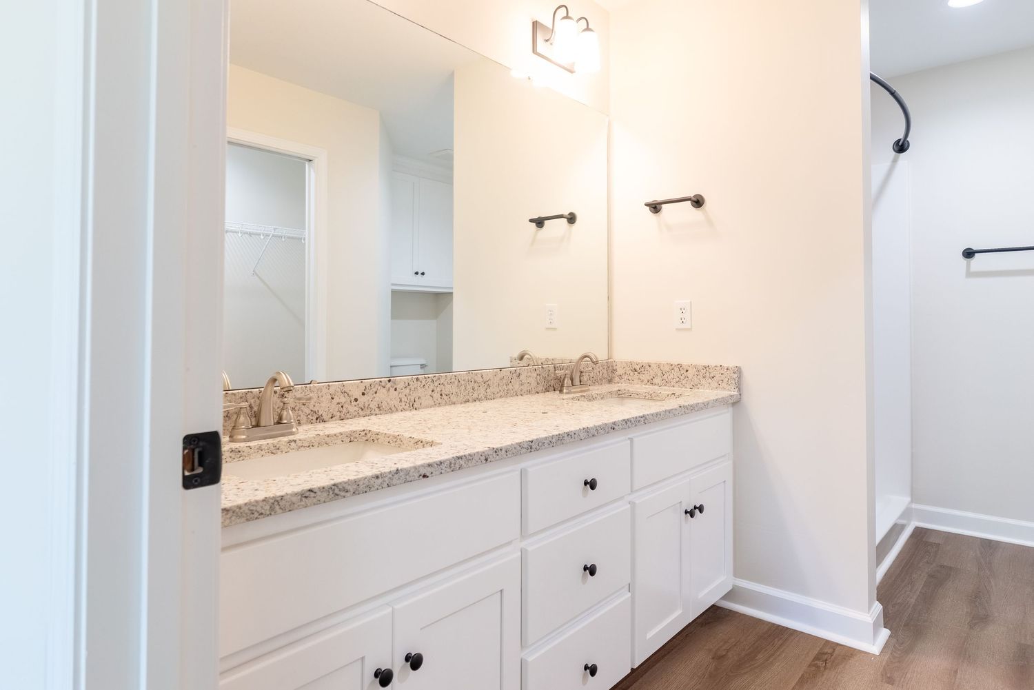Primary en suite bathroom with granite, double sinks, walk in shower, and pocket door to walk-in closet.  Located in Enterprise, Alabama.