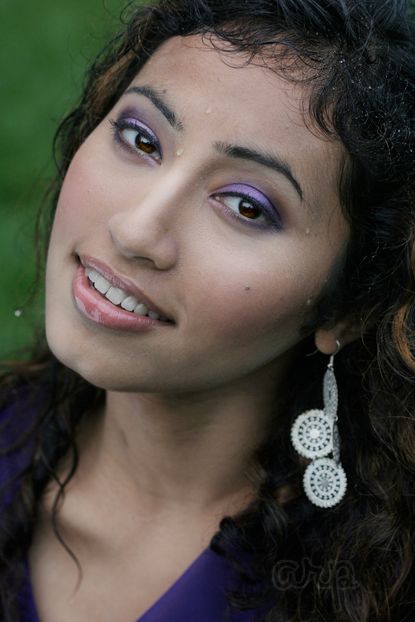 A closeup photo of a woman with raindroplets on her face.