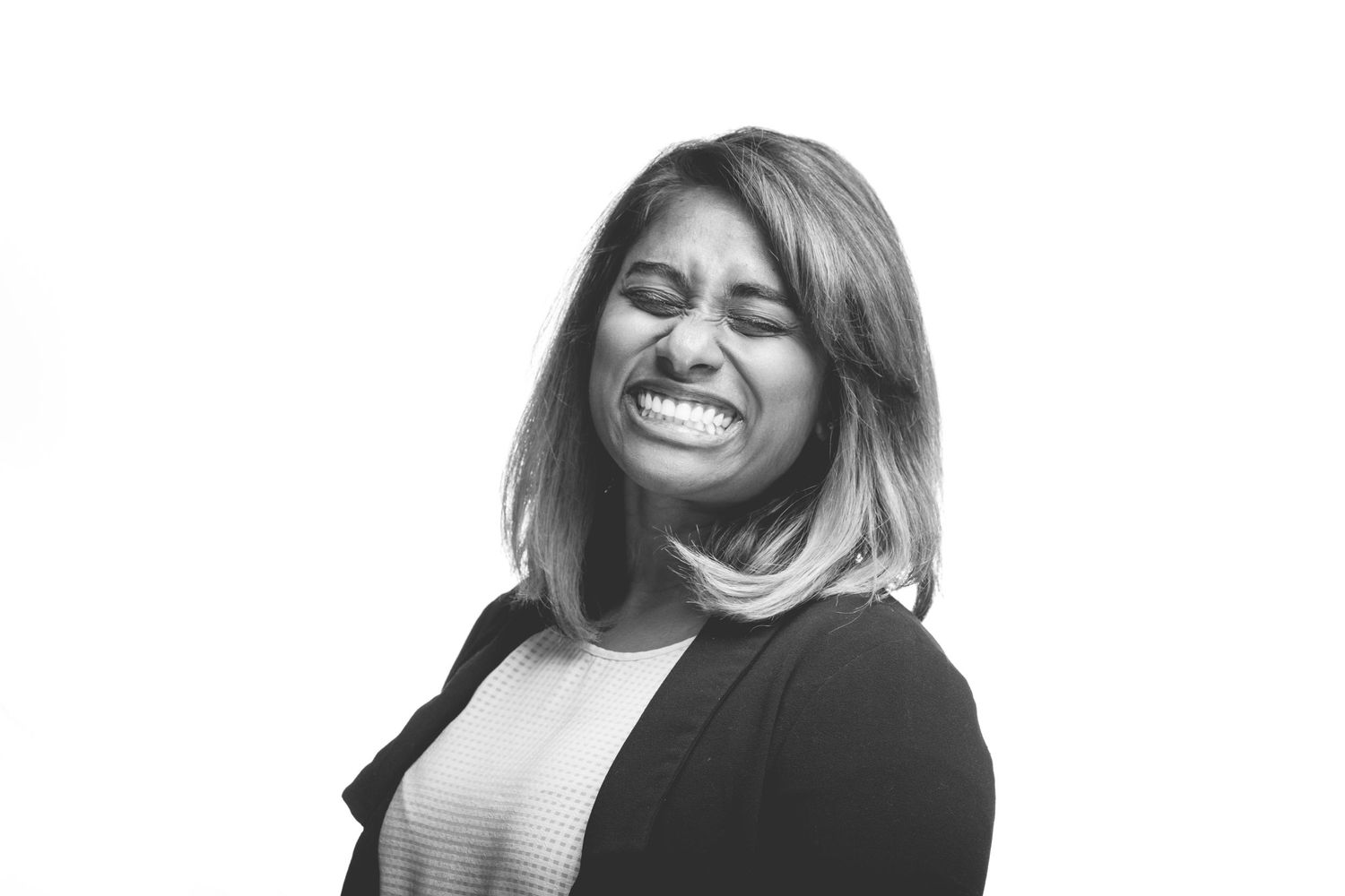 Black and White Photo of the Photographer turned slightly to the left, eyes closed and smiling very wide.
