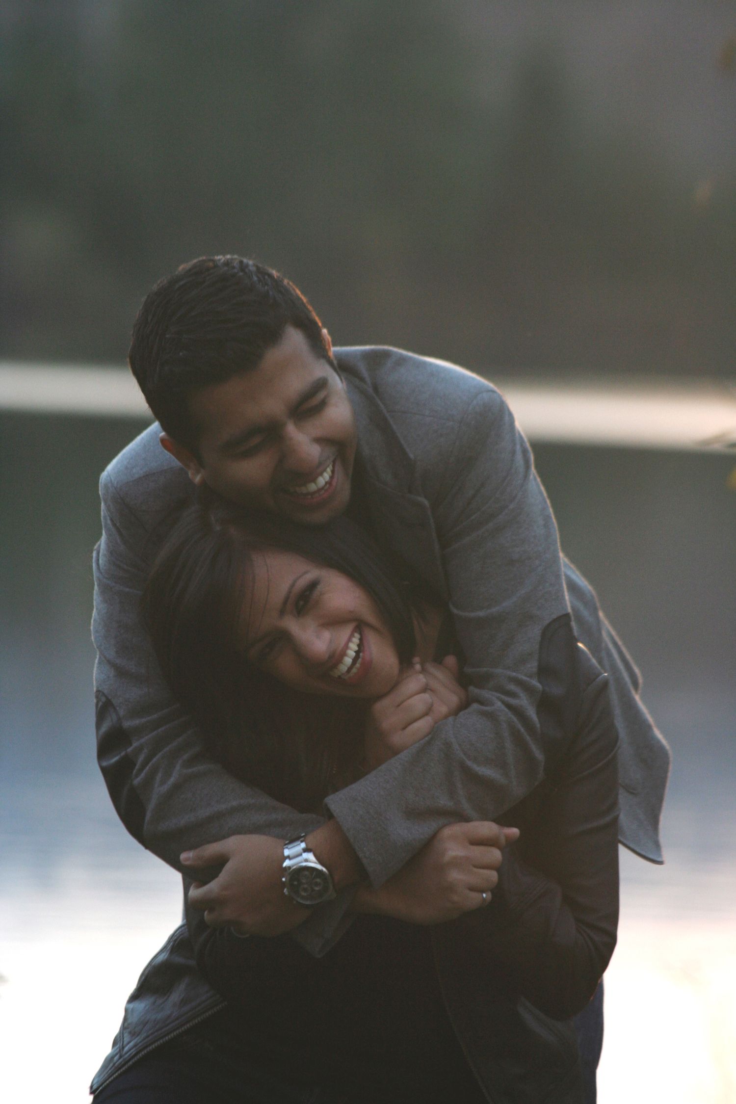 Photo of a young couple hugging and laughing.