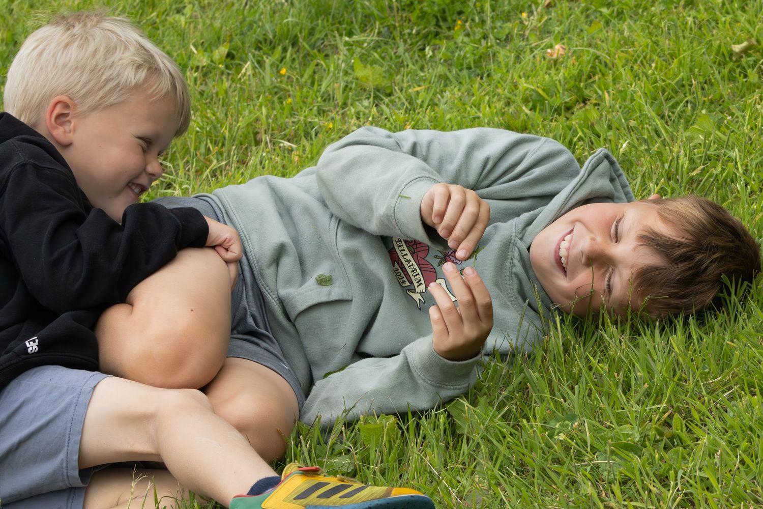 Candid moment of relaxation on green grass during a sunny day outdoors.