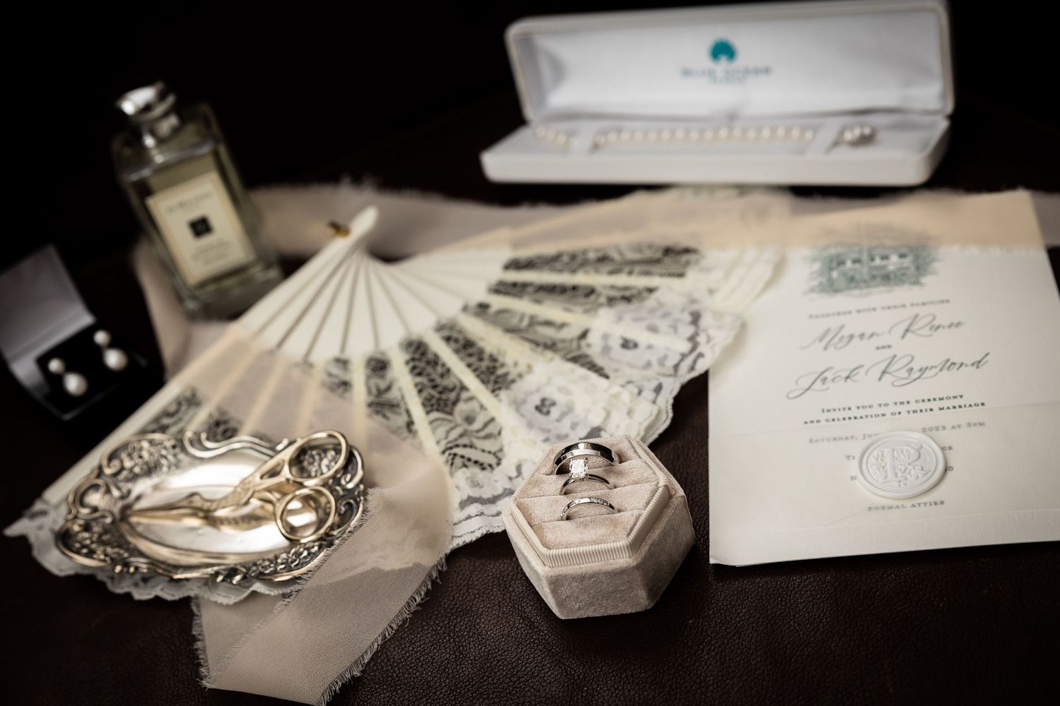 Wedding rings and invitation suite arranged artistically in soft natural light.