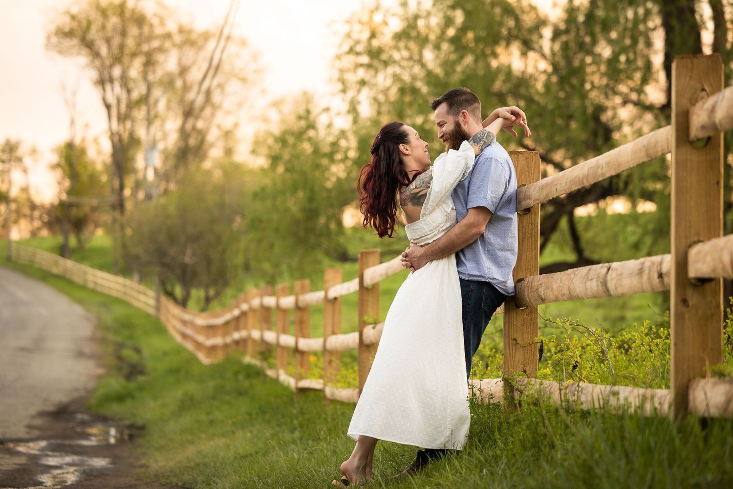 A romantic couple shares tender moments in a scenic outdoor setting during golden hour photography session.