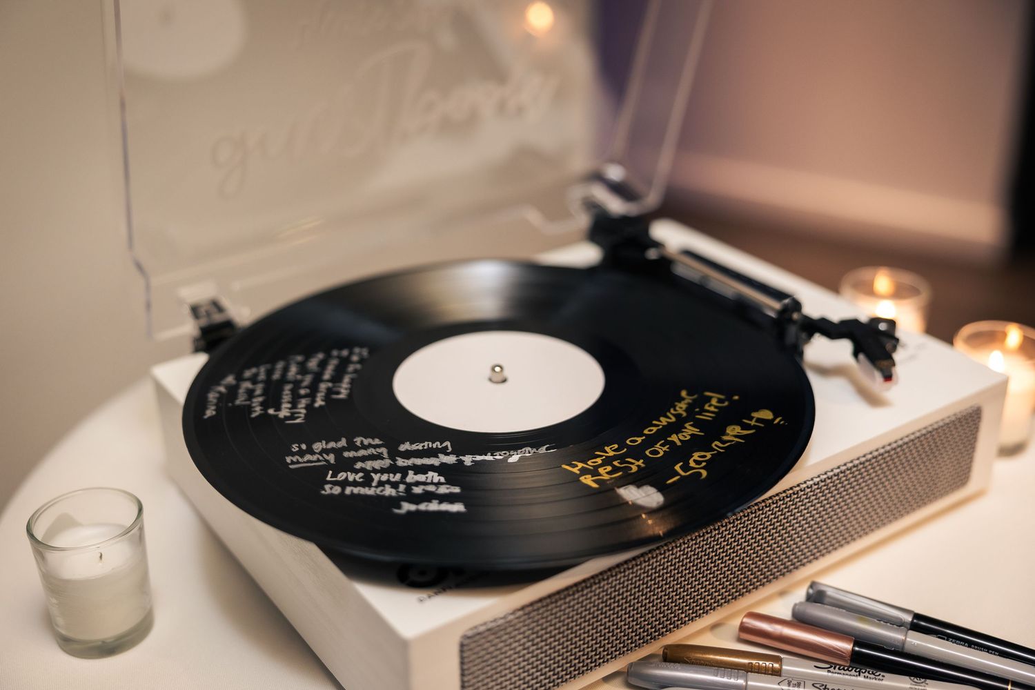 A vintage vinyl record player with a black record spinning on the turntable in warm ambient lighting.