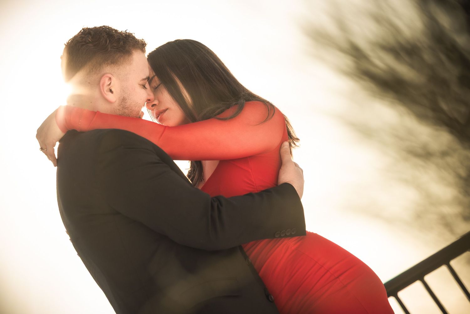 A romantic couple in formal attire embracing and dancing in a dimly lit setting.