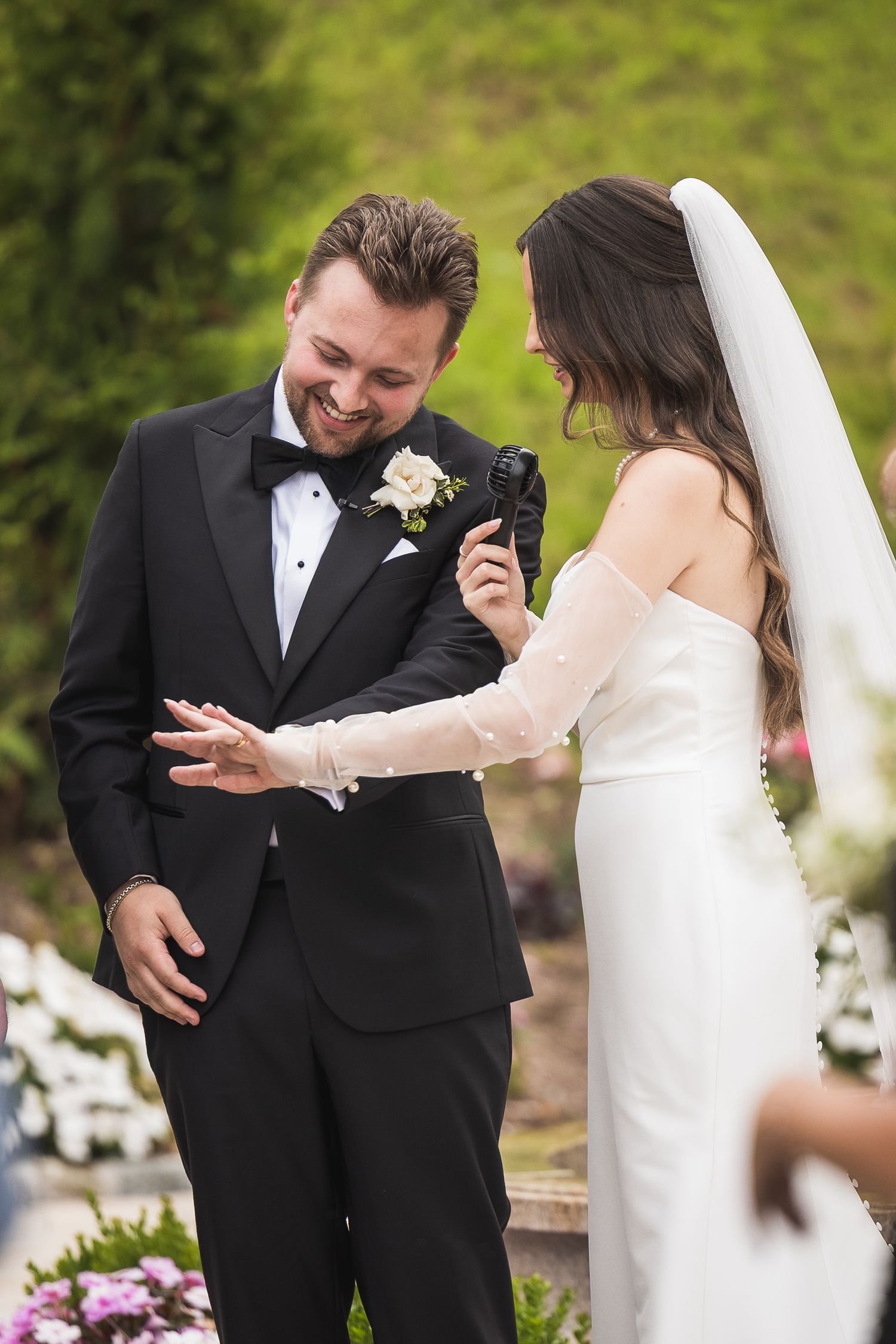 Candid wedding moment captured in a garden setting with white floral decorations.