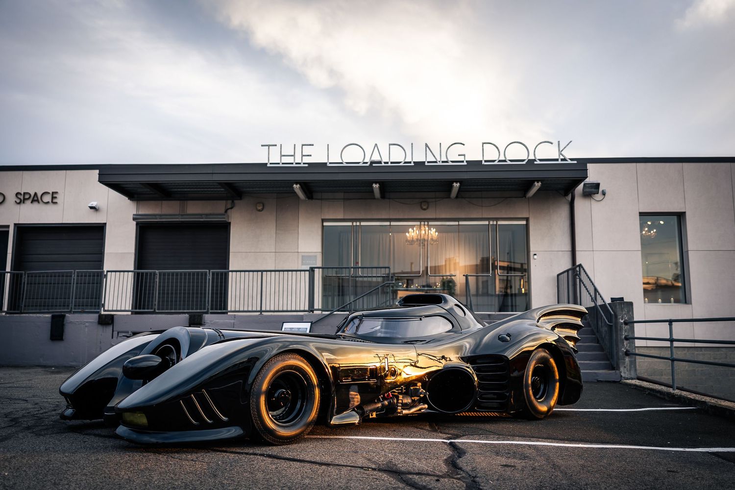 A sleek Formula 1 racing car with orange wheels displayed in a modern showroom setting.