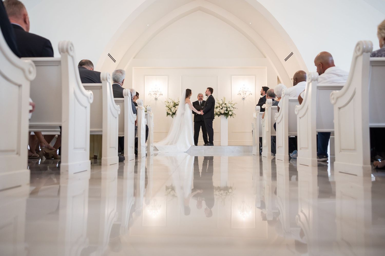 Panoramic view of a luxurious white wedding venue with arched ceilings and elegant decor.
