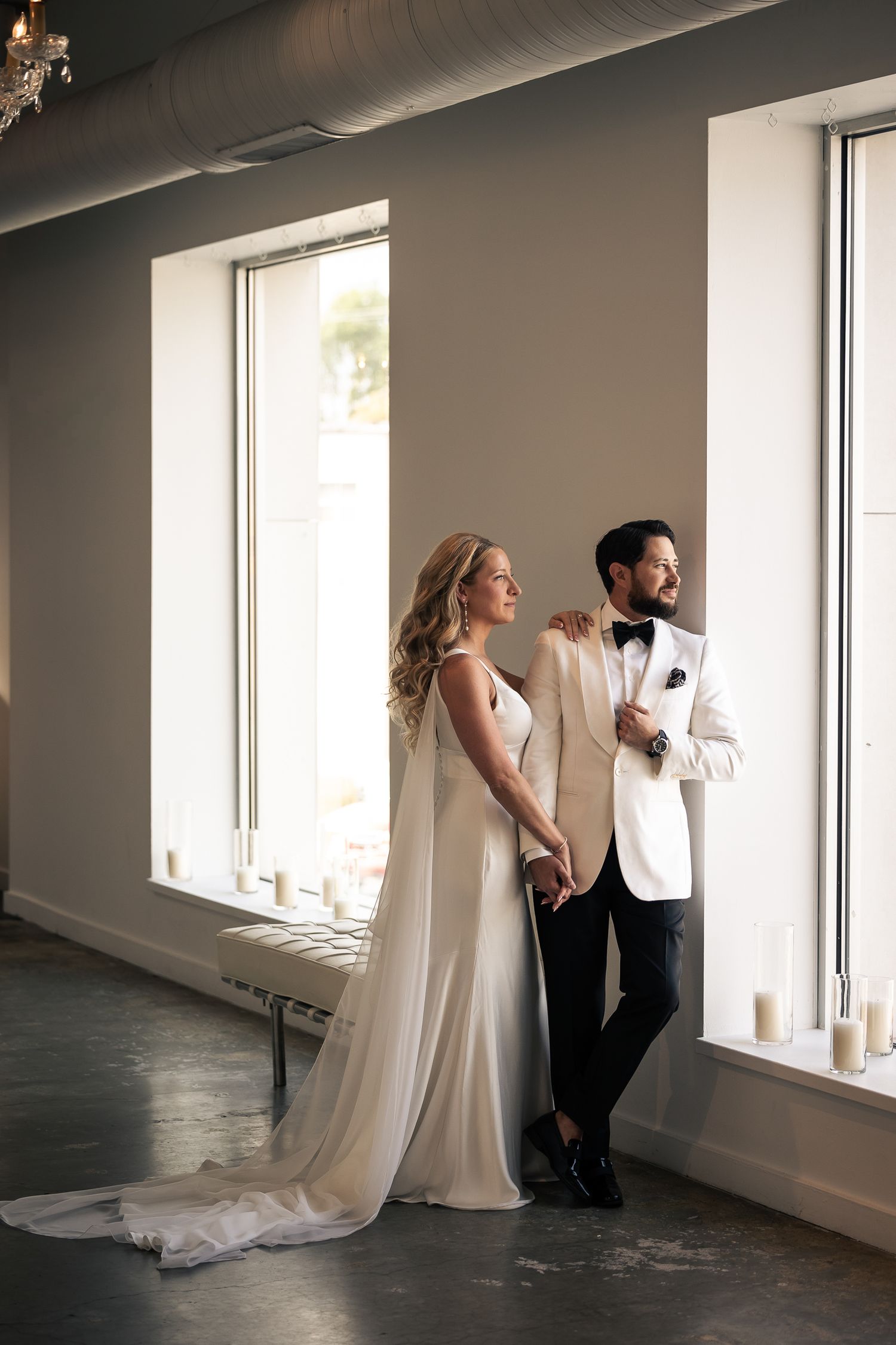 A series of artistic wedding photos showing a couple in formal attire posing by bright windows in an elegant space.