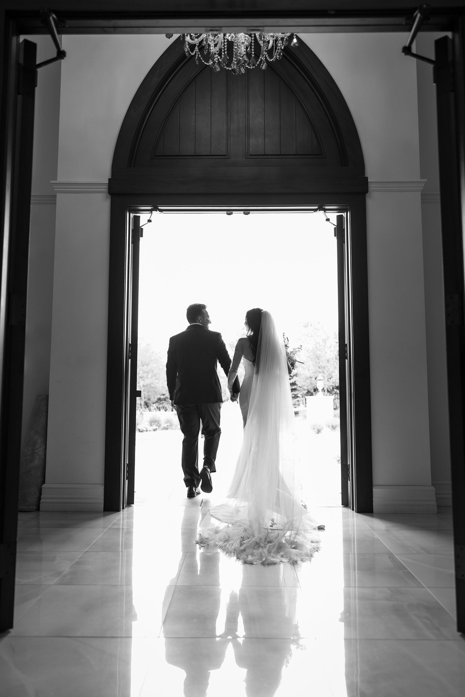 Silhouetted figures in doorways create dramatic black and white wedding portraits.