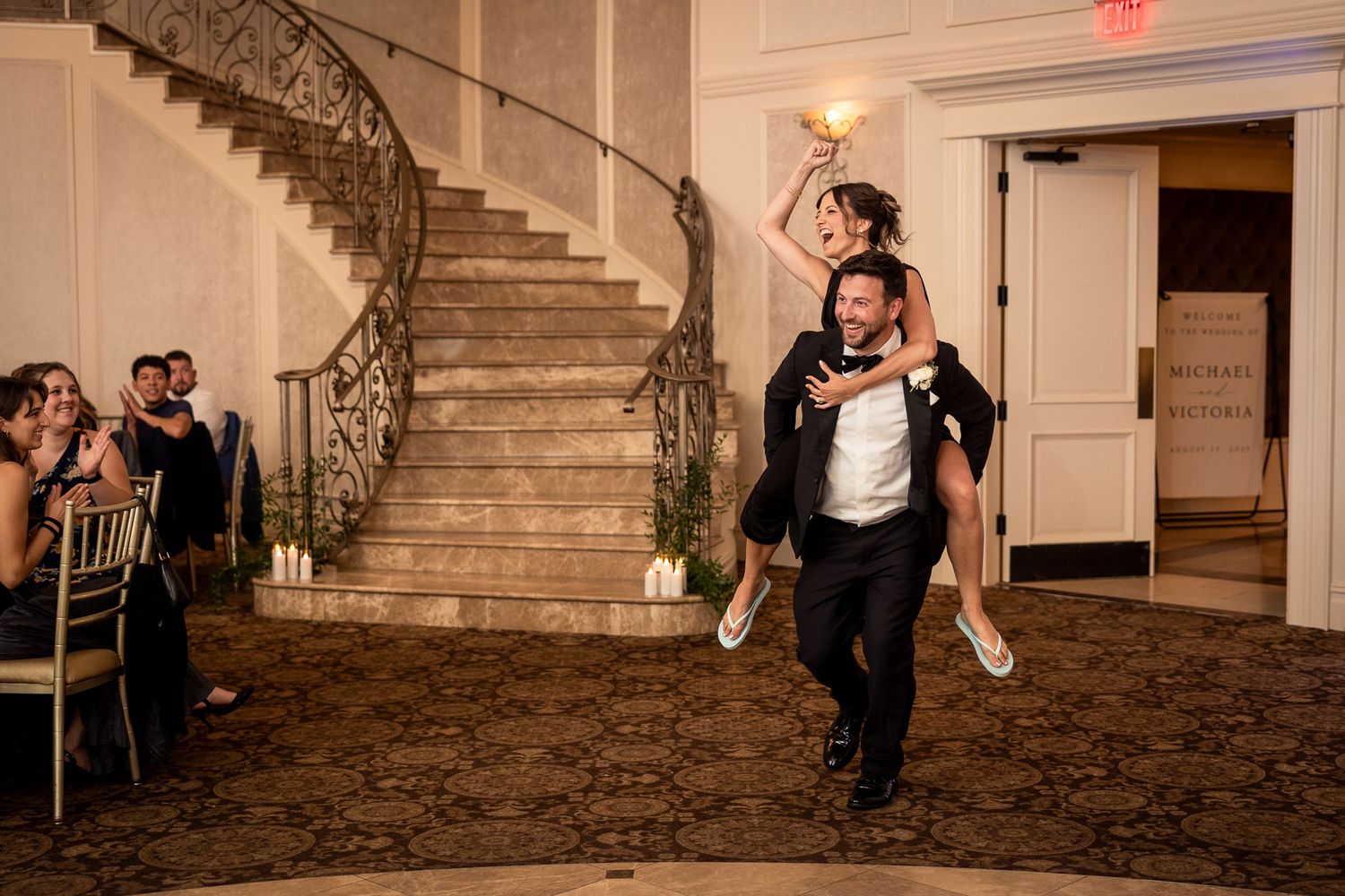 Wedding party performs choreographed dance routine in grand reception hall.
