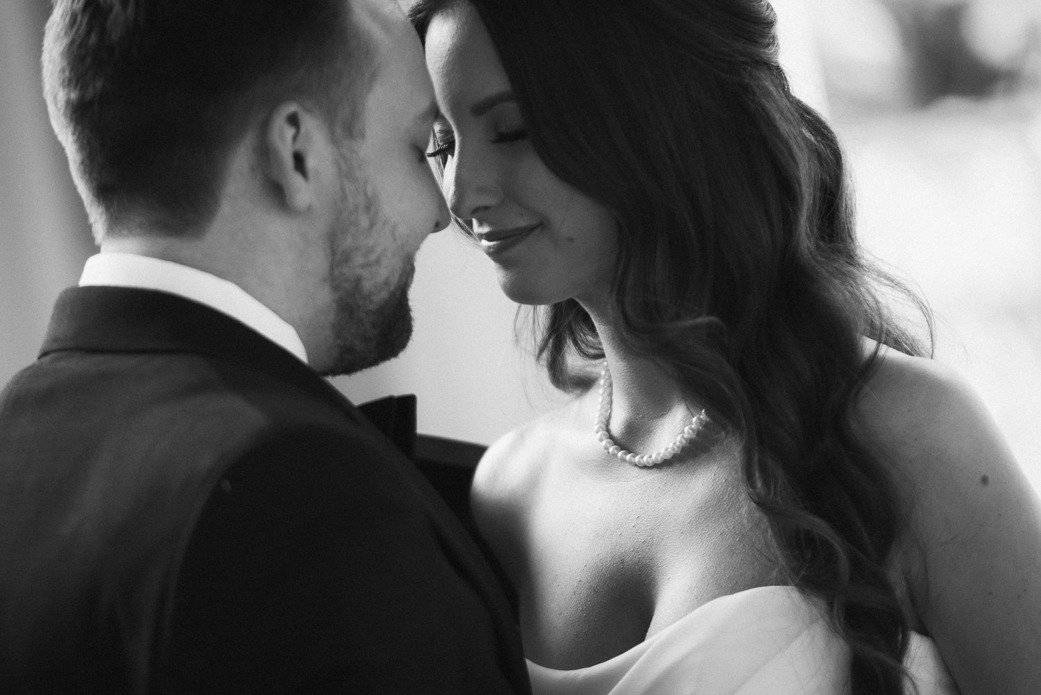 Intimate black and white portrait of newlyweds sharing a tender moment.