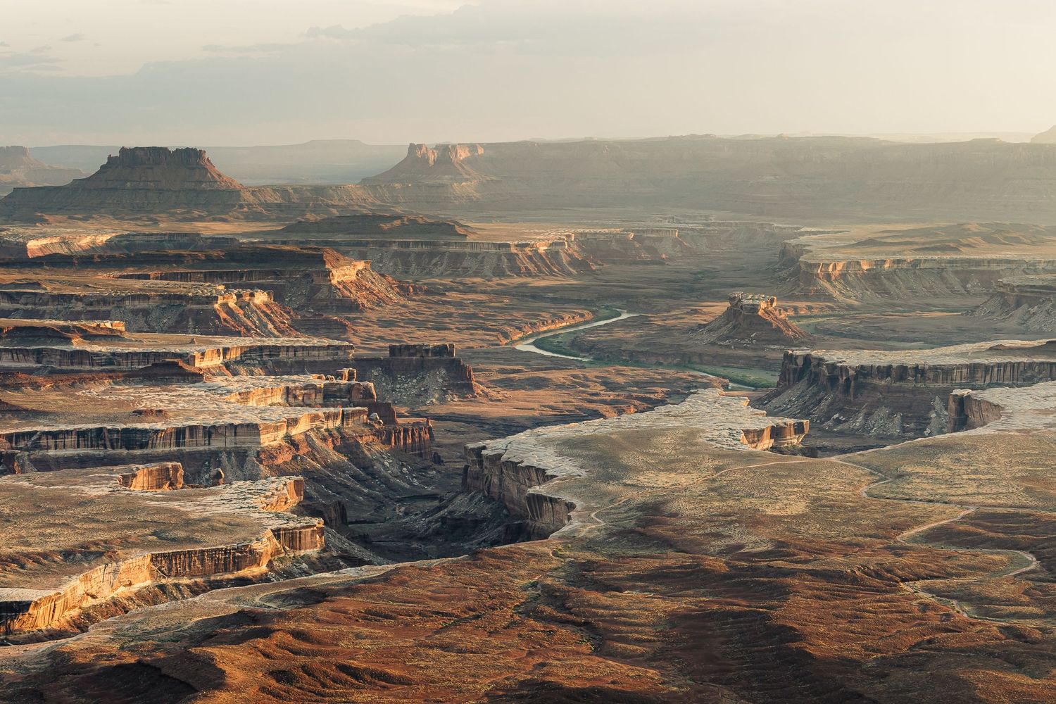 Panoramic aerial view of the Dead Horse Point State Park in Utah showing dramatic red rock canyons and mesas at sunset.