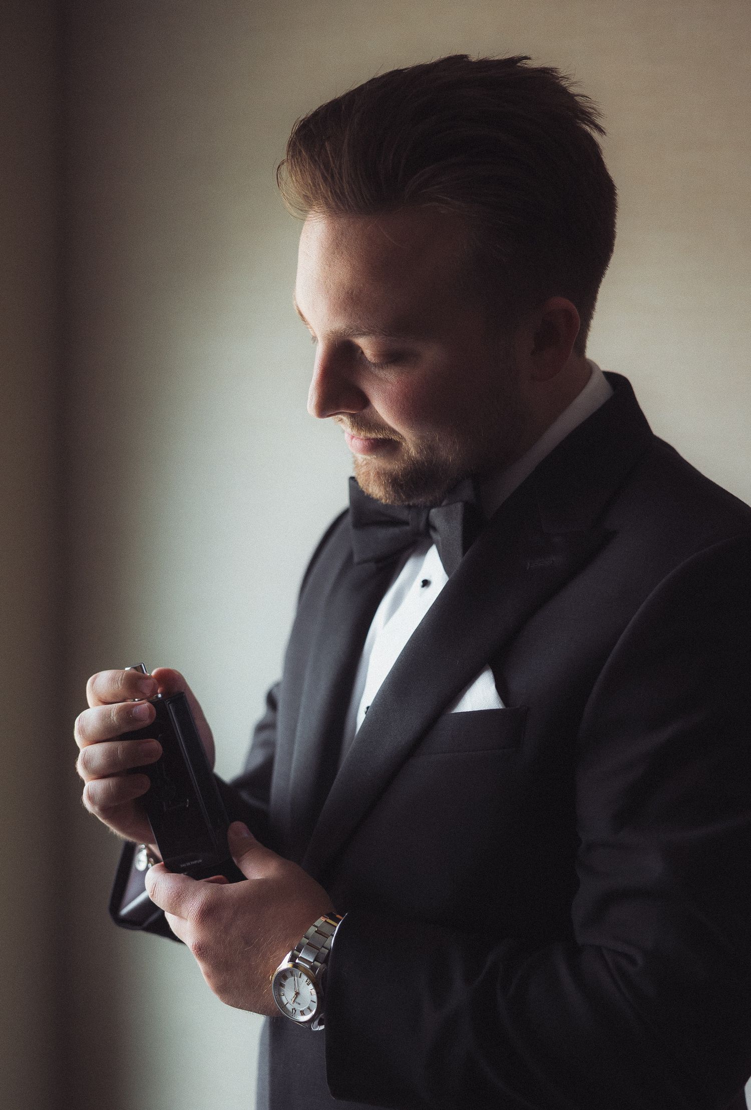 Silhouette profile shots of groom getting ready in formal attire.
