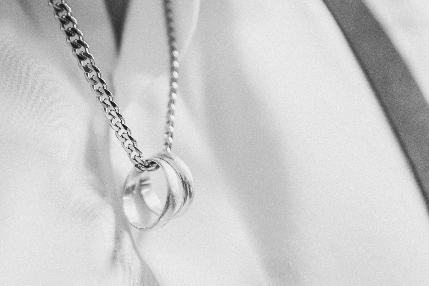 Delicate silver jewelry chain detail against a white background.
