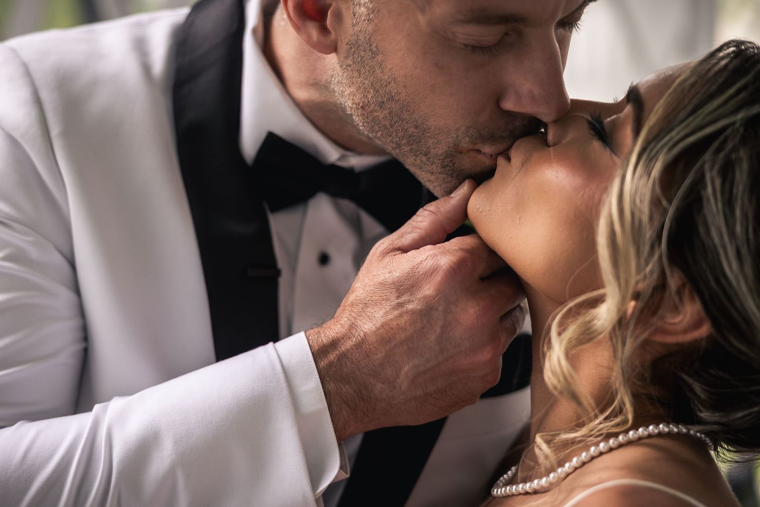 Close-up romantic moment between newlyweds in formal wedding attire.