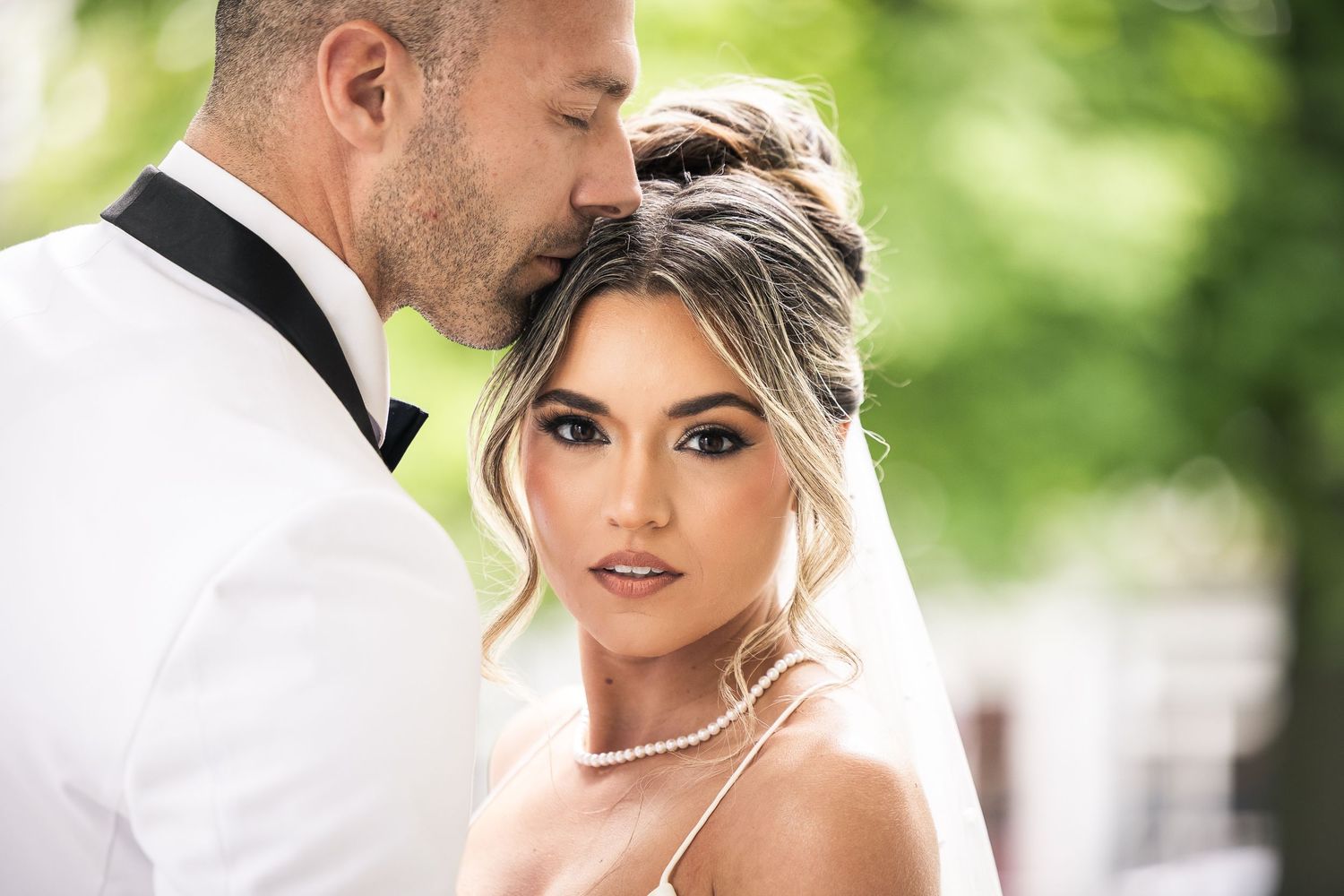 Close-up portrait shots of a bride with elegant makeup and hair styling.