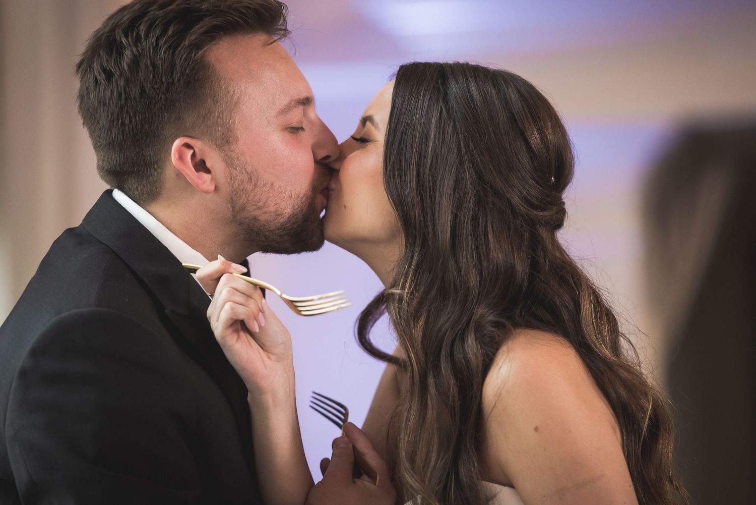 Close-up of tender wedding dance moment in a softly lit reception venue.