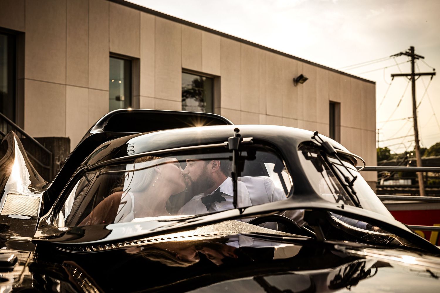 A row of classic vintage cars parked in a line showing their sleek profiles against a sepia-toned background.