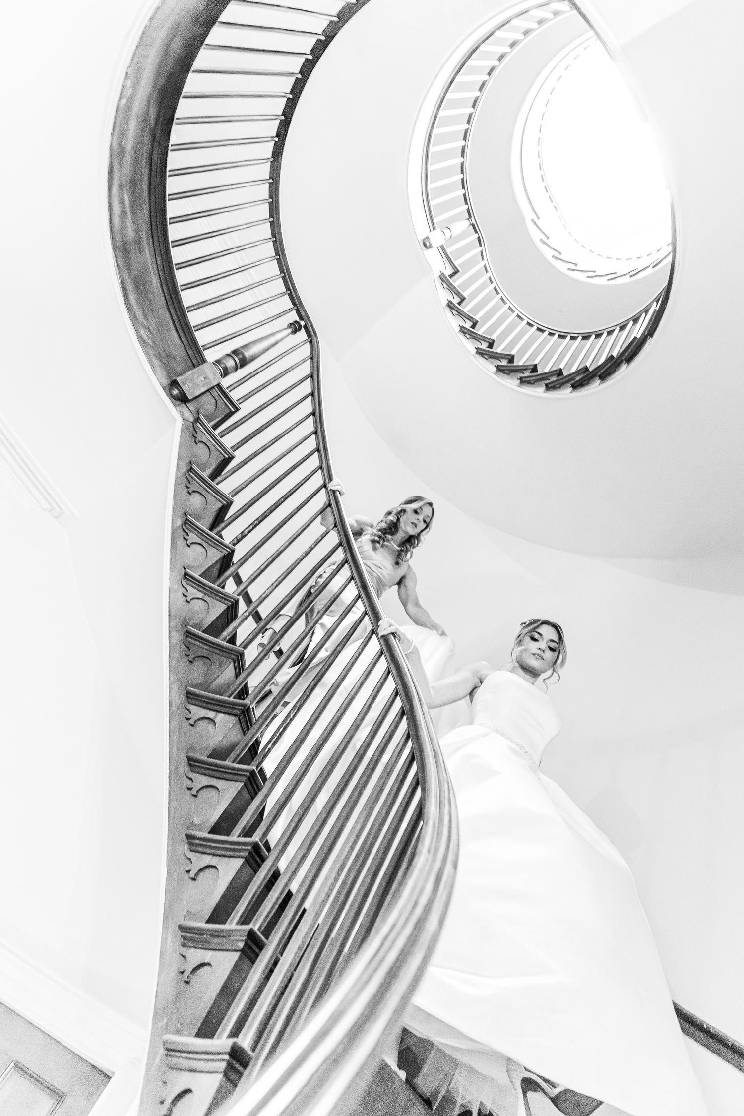 Artistic black and white shot of a spiral staircase with flowing white fabric.