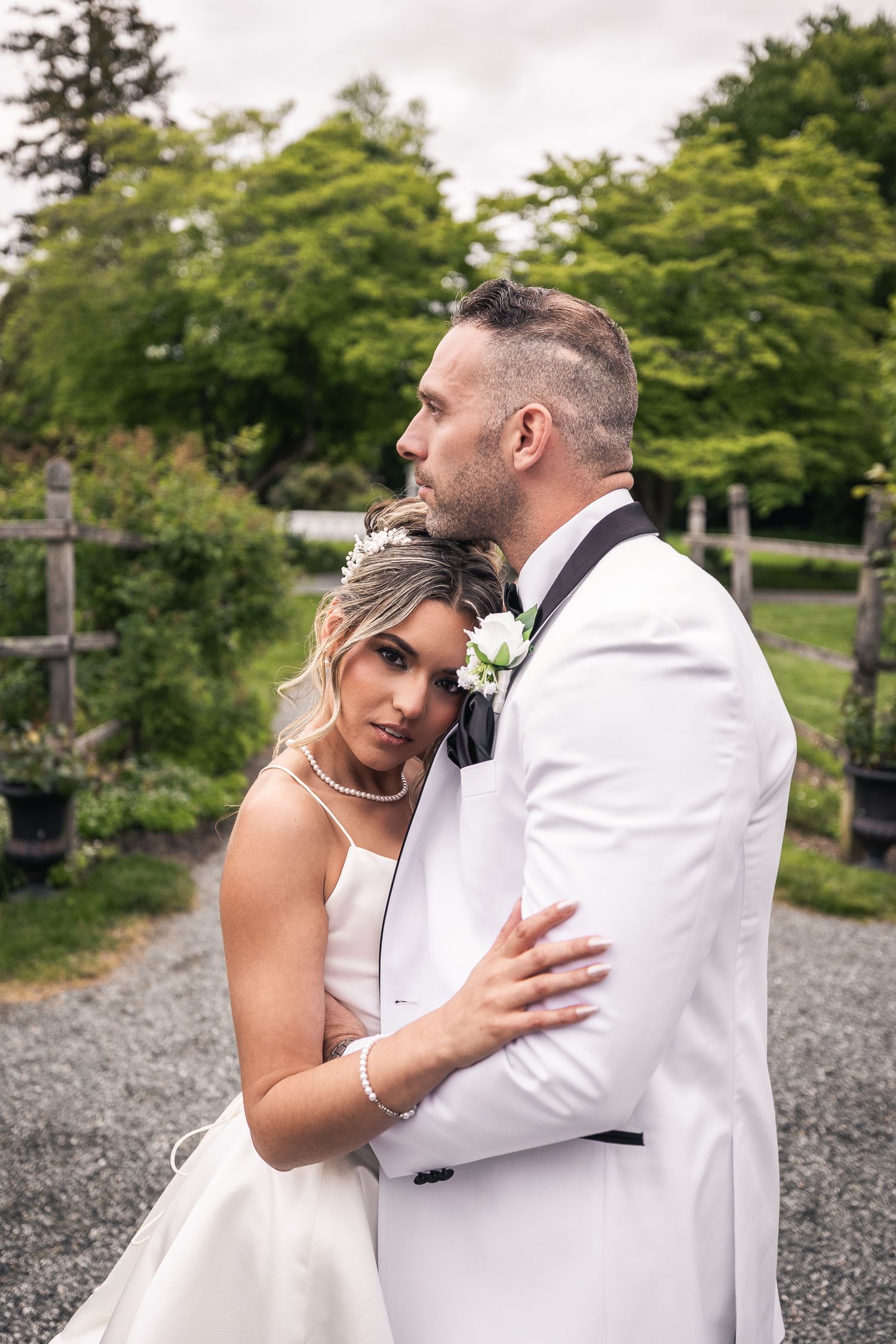 Intimate wedding couple portraits on gravel path surrounded by lush greenery.