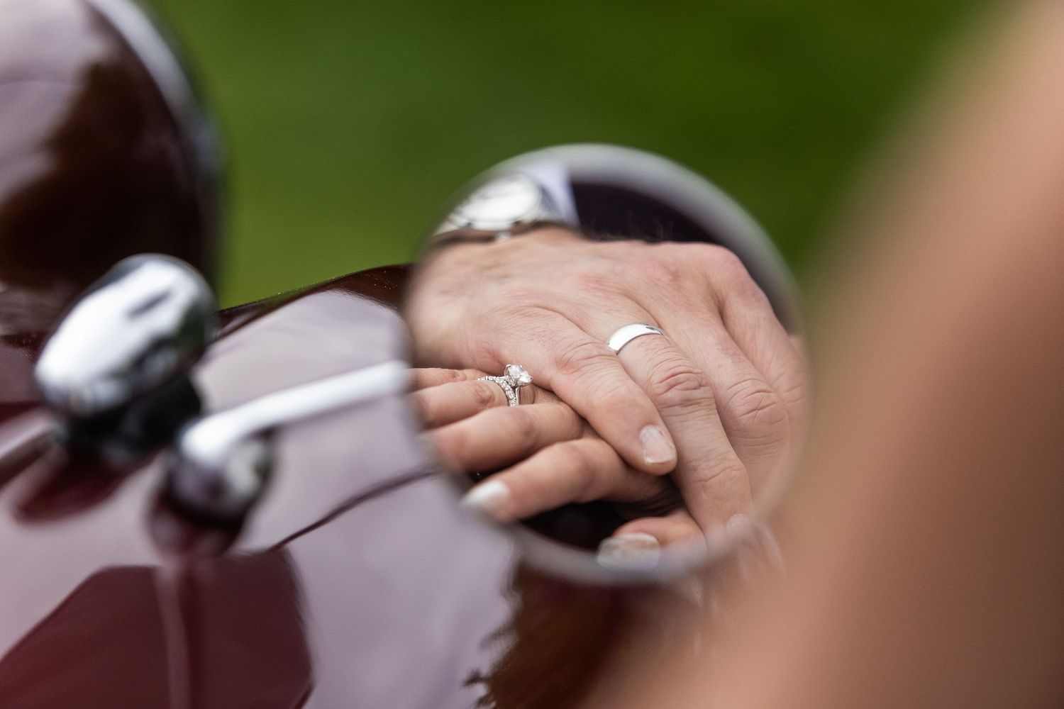 Close-up shot of hands exchanging wedding rings during ceremony.