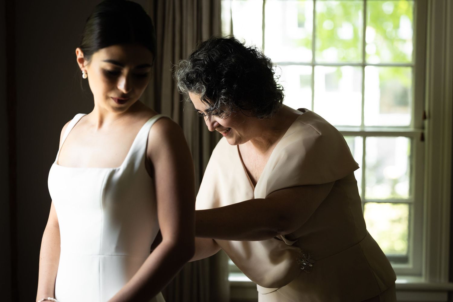 Artistic black and white wedding preparation photos near sunlit windows.