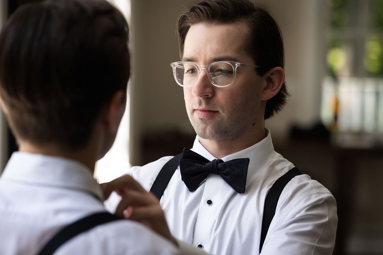 Wedding party members adjusting ties and formal attire before ceremony.