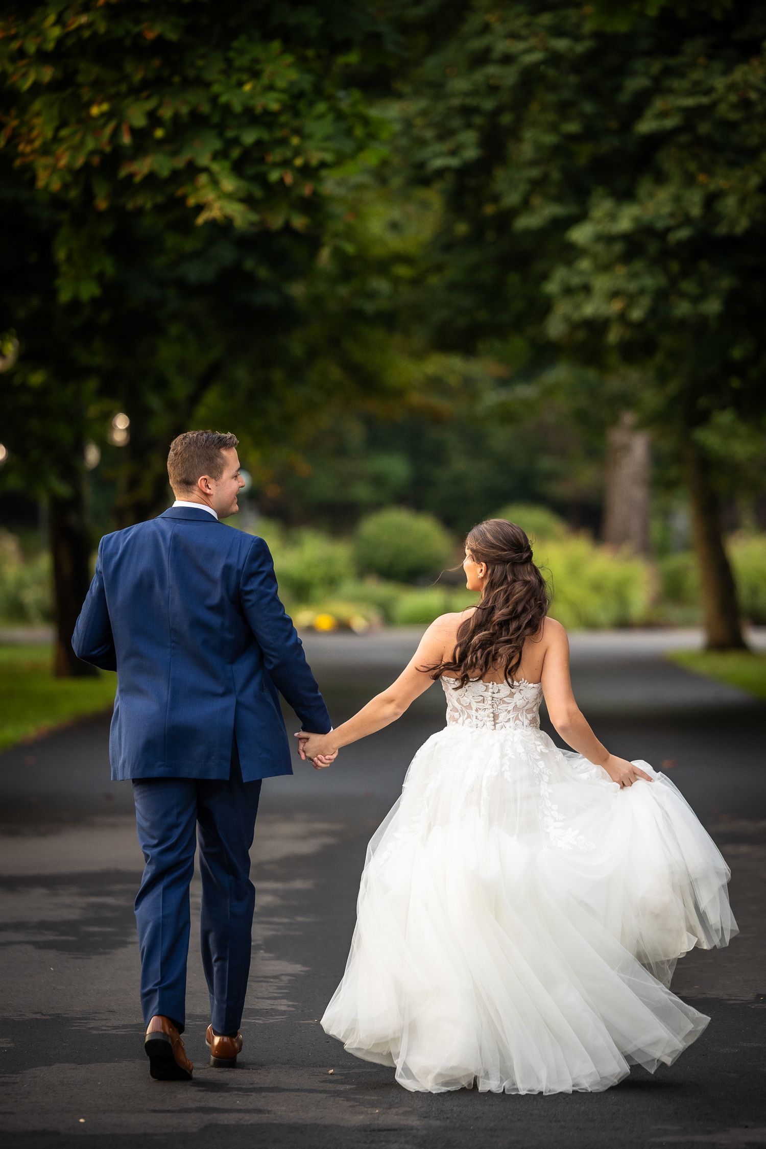 A couple in wedding attire walking together on a path, shown in a series of candid moments.