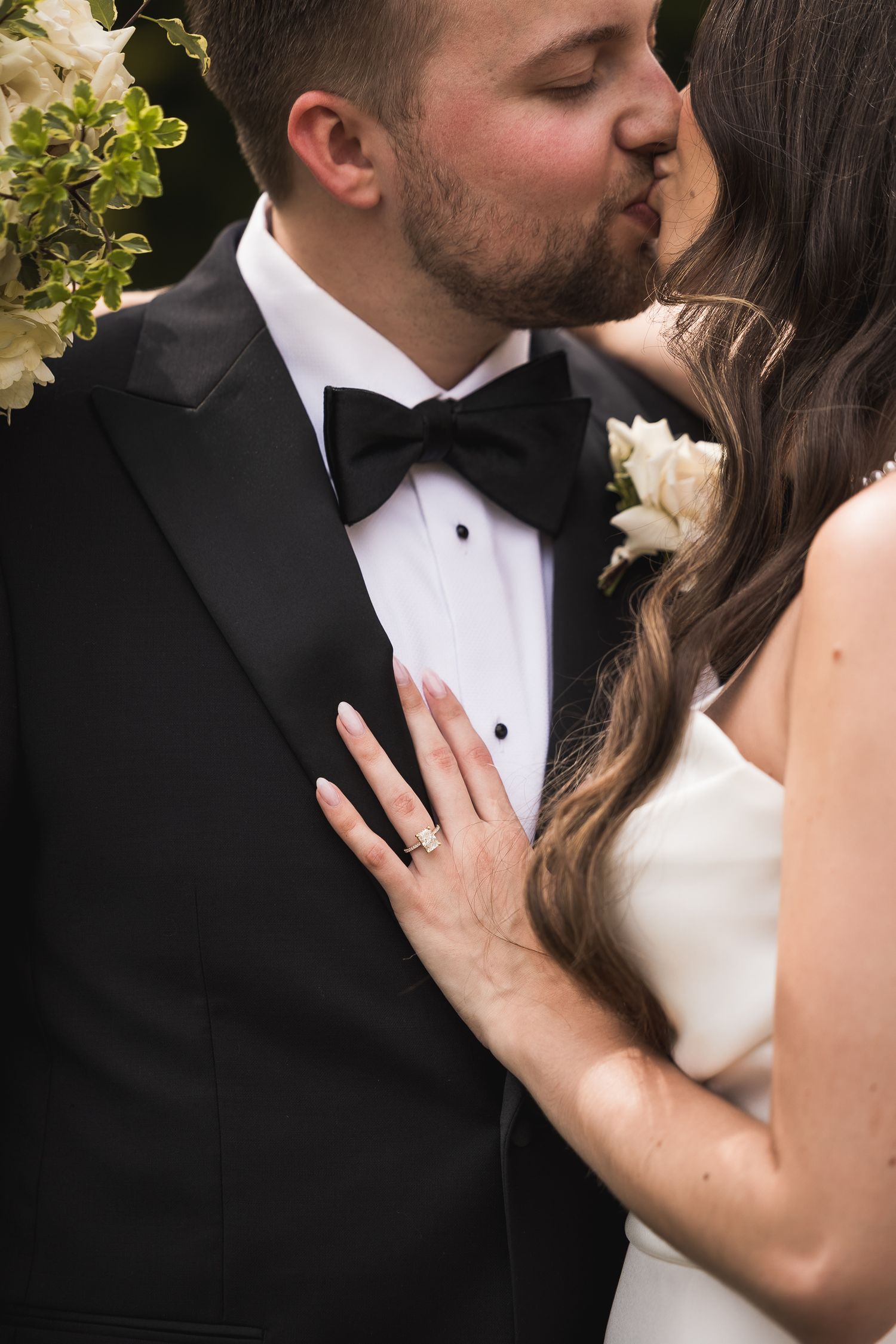 Close-up romantic moment captured between newlyweds in formal wedding attire.