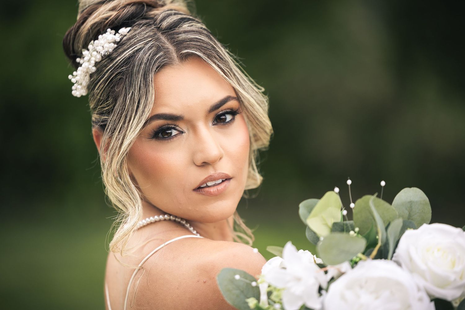 Close-up bridal portrait with white flowers and delicate headpiece.
