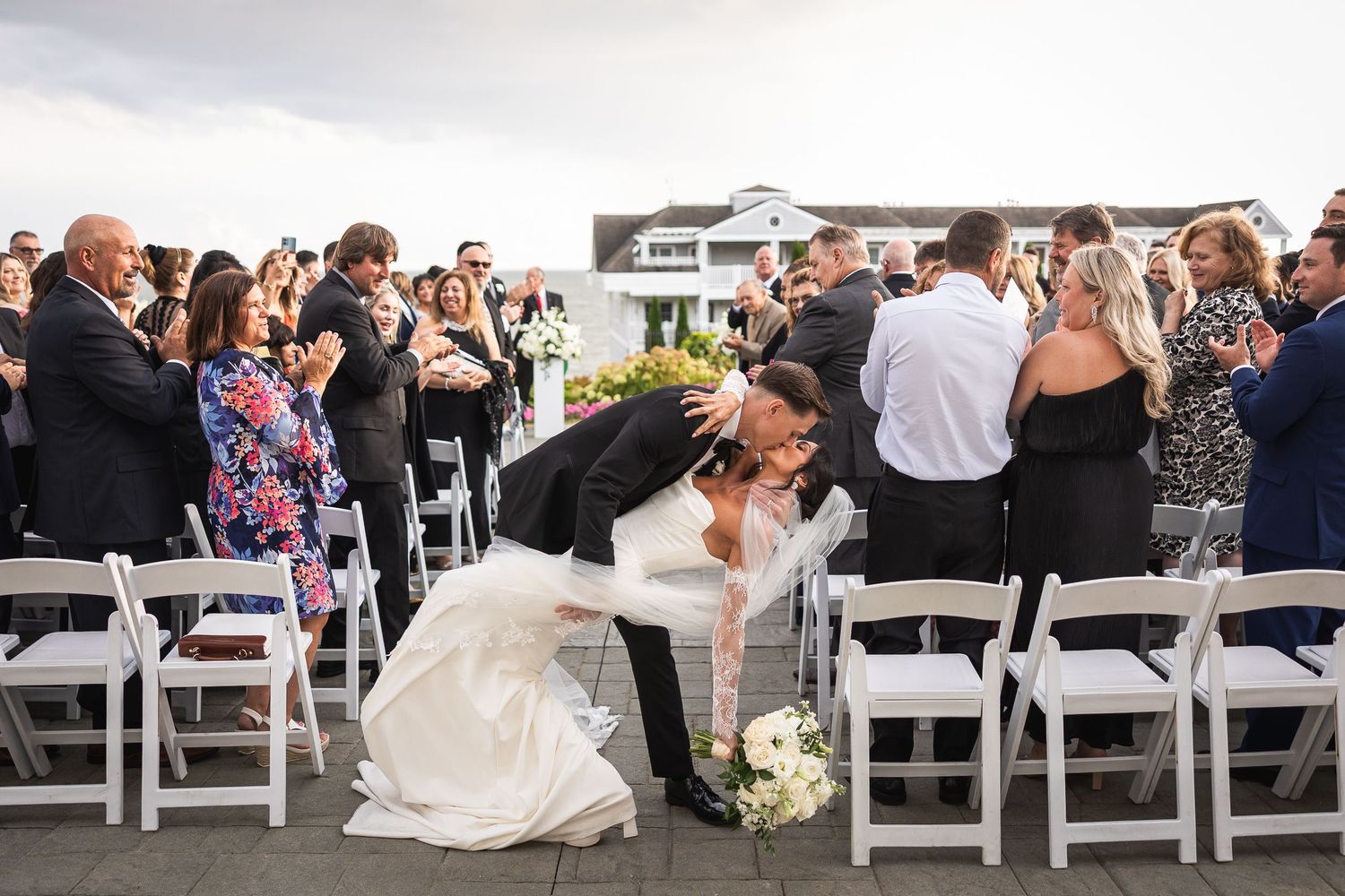 Celebratory moment during an outdoor wedding ceremony with guests applauding.